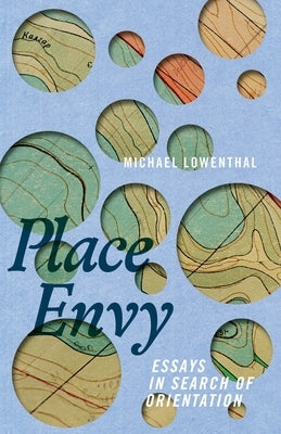 Paperback book "Place Envy: Essays in Search of Orientation" by Mad Creek Books displayed on a wooden surface.